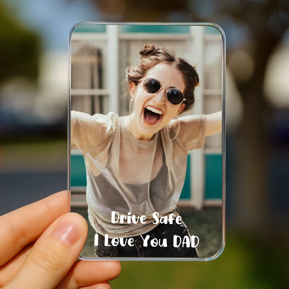 car visor clip with a photo of a person wearing sunglasses and text 'Drive Safe, I Love You DAD' held by a hand.