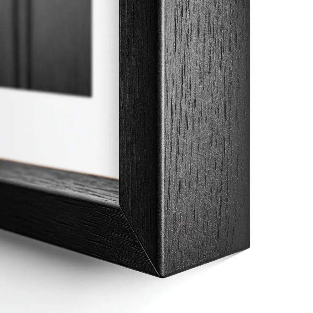 Close-up of a black wooden picture frame corner on a white background